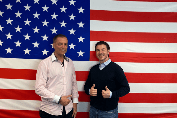 The American Dream managing director Holger Zimmermann and actor Saša Kekez in front of the American flag.