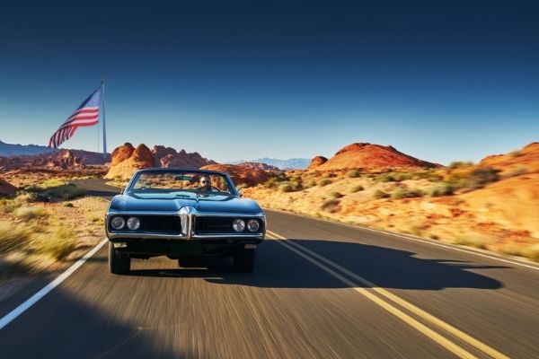 A Mustang driving over an american country road