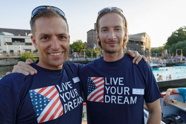 Holger and Marcus in front of a swimming-pool wearing Live Your Dream t-shirts