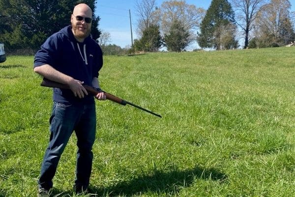 Enrico holds an air rifle in his hand.