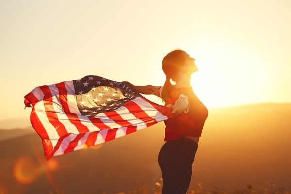 Woman with US flag during sunset