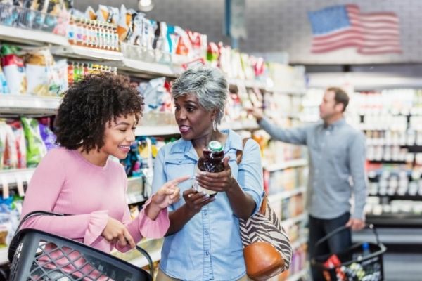 Three people standing between supermarket shelves in an American mega store.